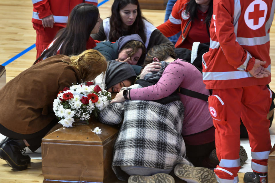 FILE - This March 1, 2023 file photo shows the relatives of the victims mourning inside the PalaMilone sports center in Crotone, southern Italy, over the coffins of the migrants who died after their boat capsized in the early morning of Sunday, Feb. 26, 2023, at a short distance from the shore in Steccato di Cutro, in the Italian southern tip, killing at least 94 people. Survivors and family members of the victims are converging in the area for a commemoration on Monday, Feb. 26, 2024, on the first anniversary of the disaster. (AP photo/Giuseppe Pipita)