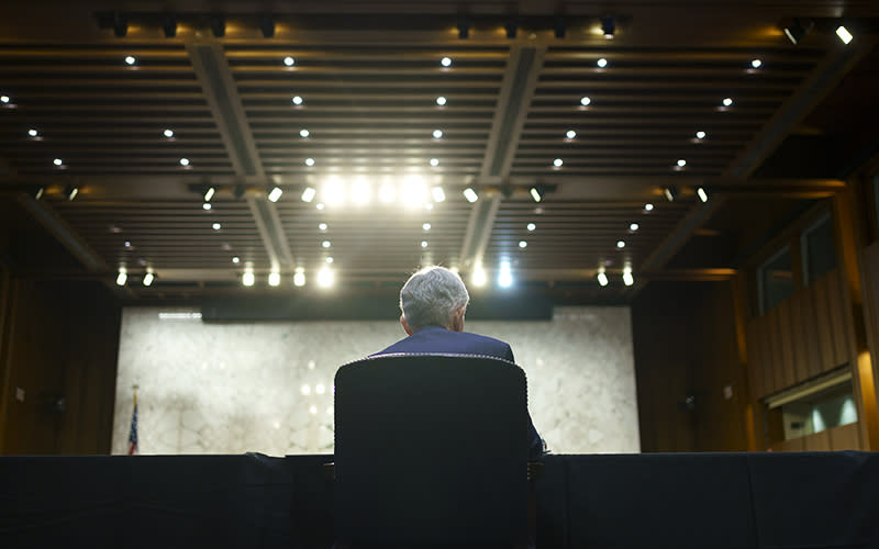 Federal Reserve Chairman Jerome Powell is seen sitting in a chair from behind