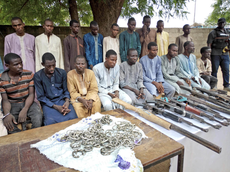 FILE - A group of men identified by Nigerian police as Boko Haram extremist fighters and leaders are shown to the media, in Maiduguri, Nigeria, Wednesday, July 18, 2018. His experience represents a worrying new development in Nigeria, Africa's most populous country where the mass abduction of Chibok schoolgirls a decade ago marked a new era of fear even as nearly 100 of the girls remain in captivity. An array of armed groups now focus on abducting schoolchildren, seeing in them a lucrative way to fund other crimes and control villages in the nation's mineral-rich but poorly-policed northwestern region.(AP Photo/Jossy Ola, File)