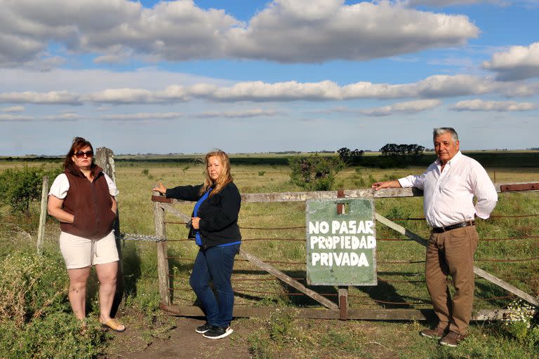 Rosana Valenzuela, Ana María y Néstor Ricardo Robles en la tranquera del campo que fue usurpado. Archivo