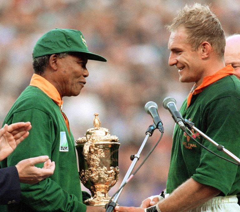 Nelson Mandela congratulates South Africa's rugby captain Francois Pienaar before handing him the Webb Ellis Cup in Johannesburg on June 24, 1995