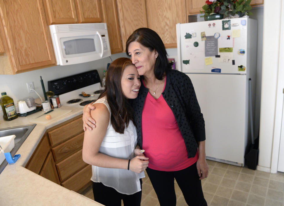 In an undated photo Julia Navarro, 58, right, hugs her daughter Lorena McKinnon in Provo, Utah. McKinnon has never been able to bring a baby to term so her 58-year-old mother is having the baby for her. They are about eight months into the pregnancy. (AP Photo/The Salt Lake Tribune, Al Hartmann) DESERET NEWS OUT; LOCAL TV OUT; MAGS OUT