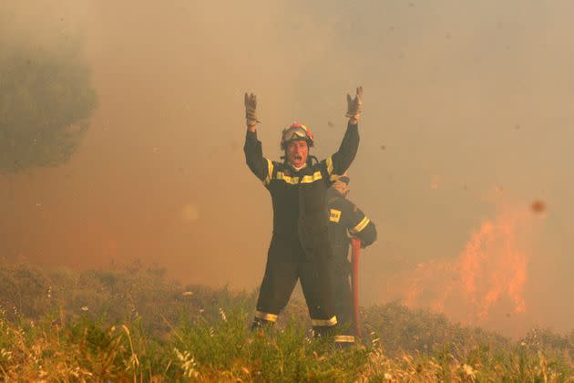 A firefighter yells while battling a forest fire in Greece. (Photo: SOPA Images via Getty Images)