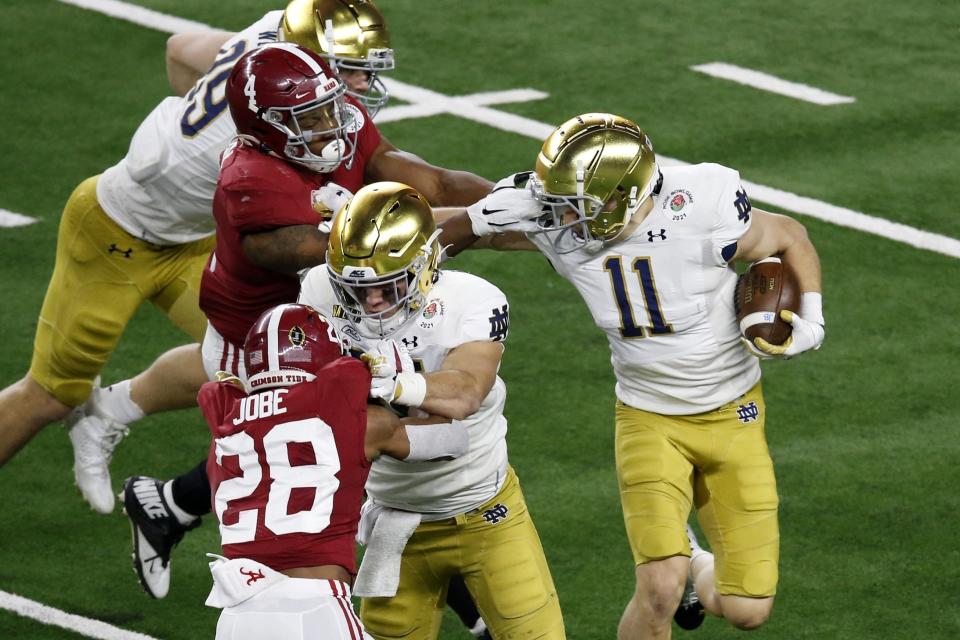 Alabama linebacker Christopher Allen (4) grabs the face mask of Notre Dame wide receiver Ben Skowronek (11) in the second half of the Rose Bowl NCAA college football game in Arlington, Texas, Friday, Jan. 1, 2021. (AP Photo/Roger Steinman)