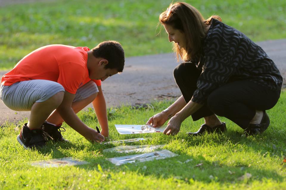 Jersey City Welcome Home volunteer, Susan Chanin, helps Ali Kaddour, 14, with an arts and craft project as his mother (not shown) takes part in an ESL class.