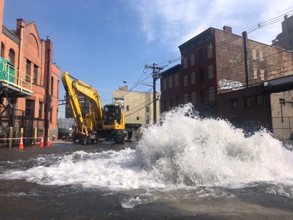 Water rushes across Observer Highway and Madison Street in Hoboken's southwest corner, after contractors ruptured a water main at a crucial junction of two service lines. Residents across the small-but-bustling city continue to wrestle with little to no water pressure more than 24 hours later.