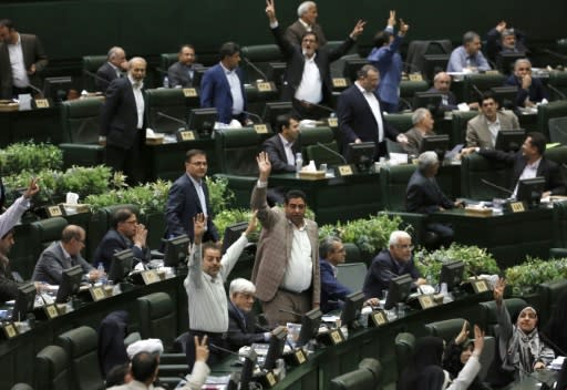 Iranian lawmakers gesture during President Hassan Rouhani's answers to the their questions in which he sought to shift the blame for the deteriorating economy to Washington even though most Iranians blame his government