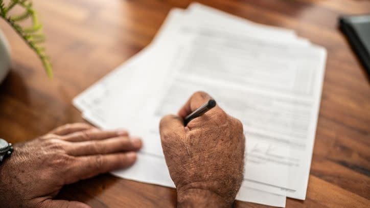 A man signs an enhanced life estate deed. 