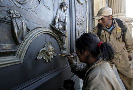 Art students restore religious figures at the "Nuestra Senora de La Paz" Cathedral in La Paz, July 7, 2015, ahead of Pope Francis' visit to Ecuador, Bolivia and Paraguay in his Latin-American tour. REUTERS/David Mercado