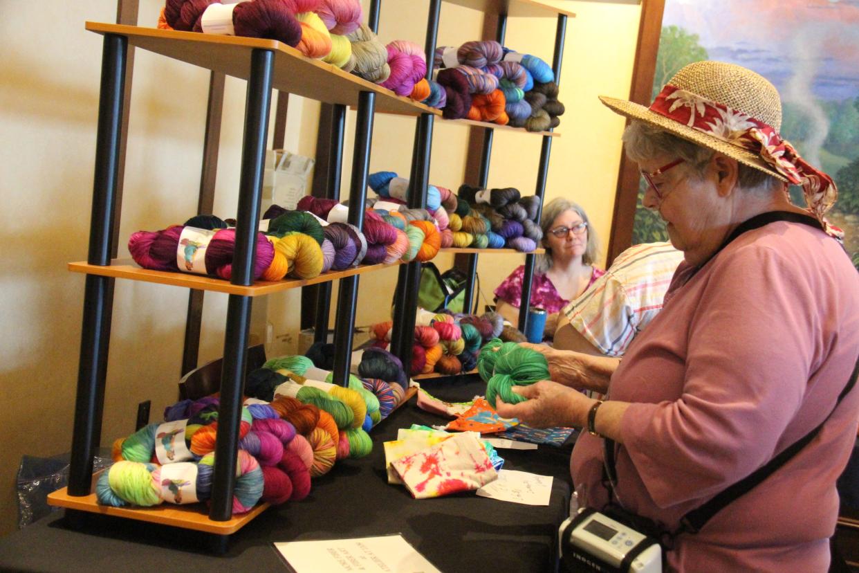 Carol Gronstal, of Carroll, checks out yarn at the Bombshell Dyeworks booth during the Fiber Festival of Perry on Saturday, May 14, 2022, at the Hotel Pattee.