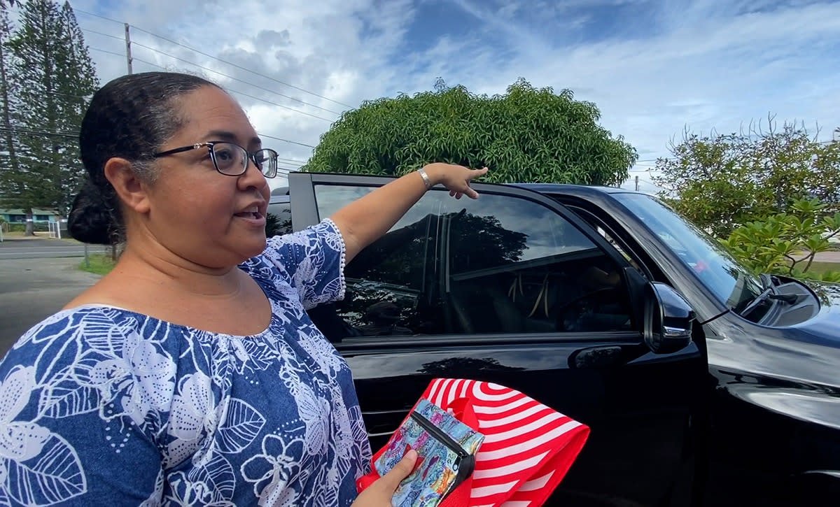 Heidi Maxie stands outside, near a car pointing