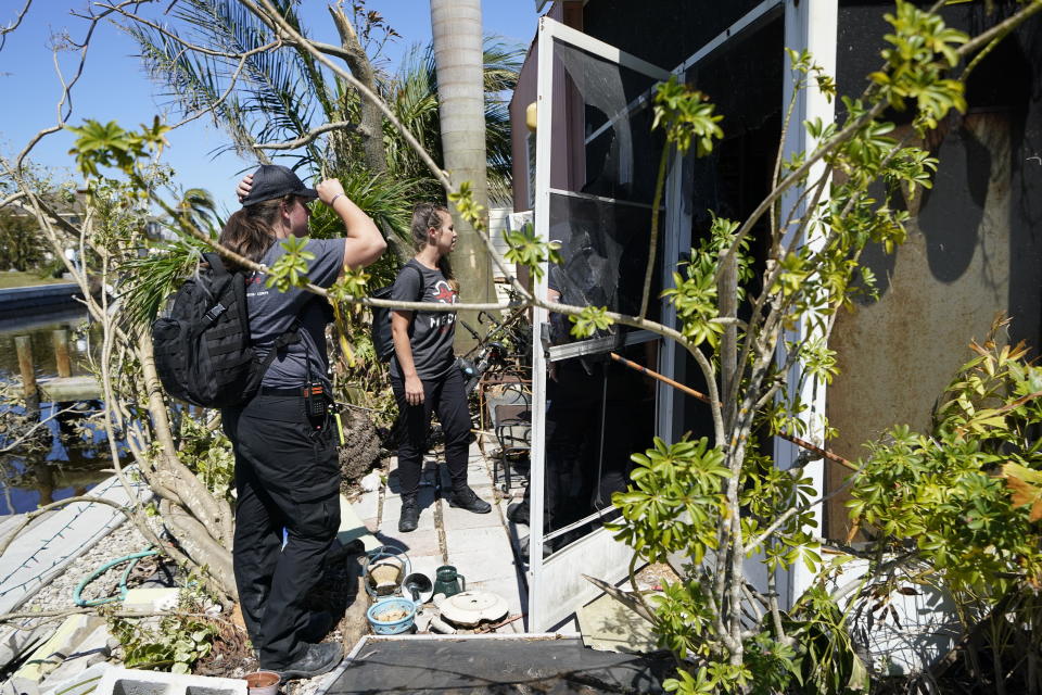 Members of mediccorps.org, which arrived on Pine Island, Fla., with two helicopters, paramedics and volunteers, searches for residents who want to evacuate in the aftermath of Hurricane Ian, Saturday, Oct. 1, 2022. The only bridge to the island is heavily damaged so it can only be reached by boat or air. (AP Photo/Gerald Herbert)