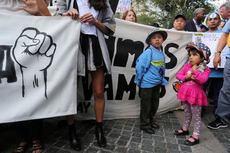 Children stand next to a banner against the U.S. President's proposed end of the DACA program that protects immigrant children from deportation at a protest in New York City, U.S., August 30, 2017. REUTERS/Joe Penney/Files