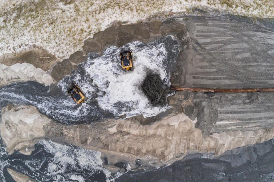 A pipe deposits sand and water from the ocean floor as sand dredging work continues in the Far Rockaway neighborhood of Queens (Copyright 2022 The Associated Press. All rights reserved.)