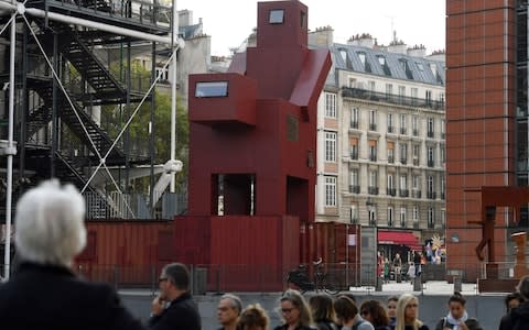 People queue in front of the art work by Dutch artist Joep Van Lieshout, "Domestikator"in front of The Centre Georges Pompidou in Paris on October 18, 2017. - Credit: ALAIN JOCARD/AFP