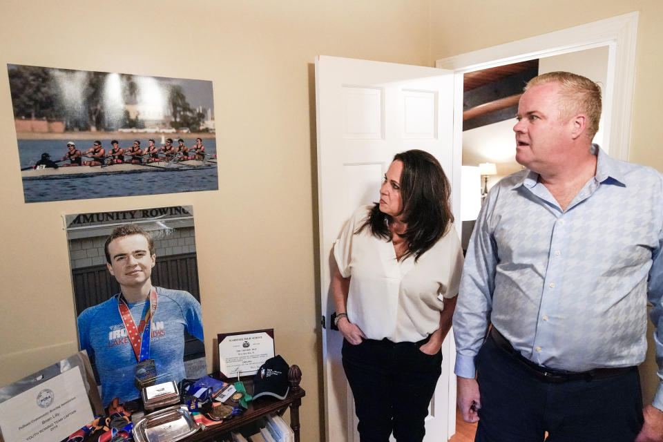 Brenda and Brian Lilly look at photos of their son Brian Lilly Jr. in their Easton, Conn. home, Thursday, Oct. 13, 2022. Brian Lilly Jr., 19, who committed suicide on Jan. 4, 2021, was a rower at University of California San Diego. The Lillys have filed a wrongful death lawsuit against the university and the rowing coach, Geoff Bond, who is no longer with the school. (AP Photo/Julia Nikhinson)