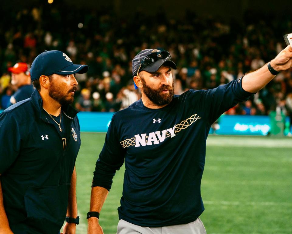 Northbridge's Jim Kiritsy, right, and Navy assistant strength coach Matt Gonzalez, left, were on the sidelines against Notre Dame in Ireland.