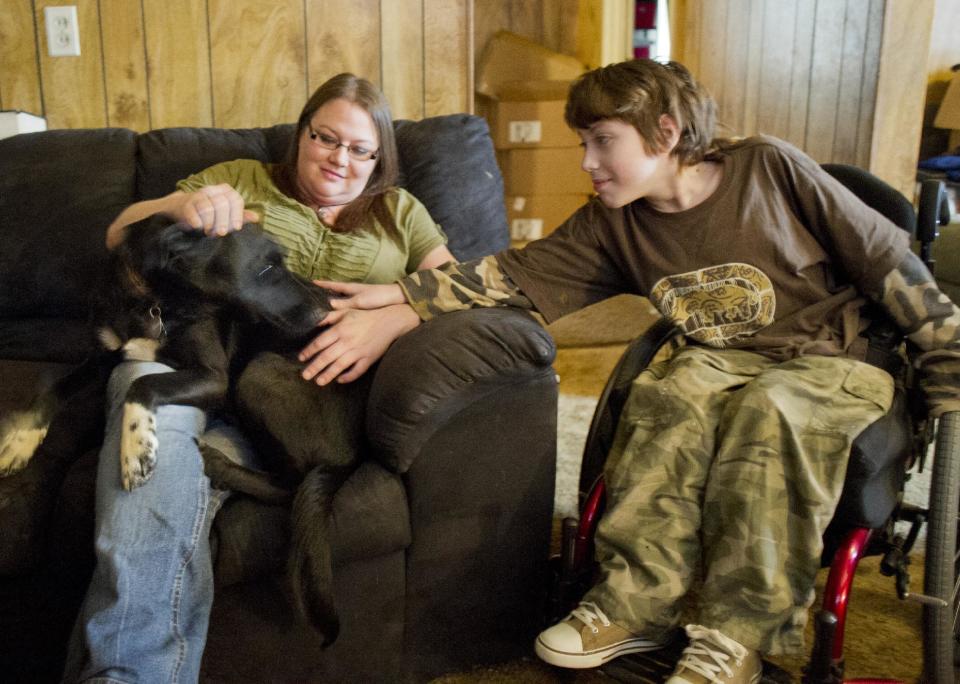 Lori Latch, left, with her son Eric Latch, right, in their home in North Little Rock, Ark., Tuesday, Feb. 4, 2014. Lori Latch, 35, said she was looking forward to having health insurance for the first time since she was a teenager. She and her husband, who is self-employed, have racked up more than $5,000 in bills for emergency room visits. Arkansas’ plan for expanding Medicaid by buying private insurance policies for the poor instead of adding them to the rolls was heralded as a model for convincing more Republican-leaning states to adopt a key part of President Barack Obama’s health care overhaul. But less than a year after its approval, the program that has extended health insurance to 83,000 people is on the brink of being abandoned. (AP Photo/Brian Chilson) (AP Photo/Brian Chilson)