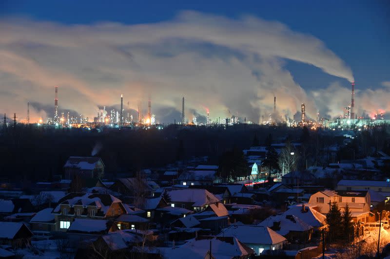 FILE PHOTO: Flue gas and steam rise out of chimneys of an oil refinery in Omsk