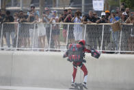 A jet suit pilot lands in Dubai, United Arab Emirates, Wednesday, Feb. 28, 2024. Dubai on Wednesday hosted what it called its first-ever jet suit race. Racers zipped along a route with the skyscrapers of Dubai Marina looming behind them, controlling the jet engines on their hands and their backs. (AP Photo/Jon Gambrell)