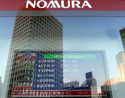 File photo of an electronic share price board in front of a Nomura Securities' branch in Tokyo. Top Japanese brokerage Nomura will cut its chief executive's pay as a penalty for an embarrassing string of insider trading scandals, reports said Friday, as regulators ramp up a probe