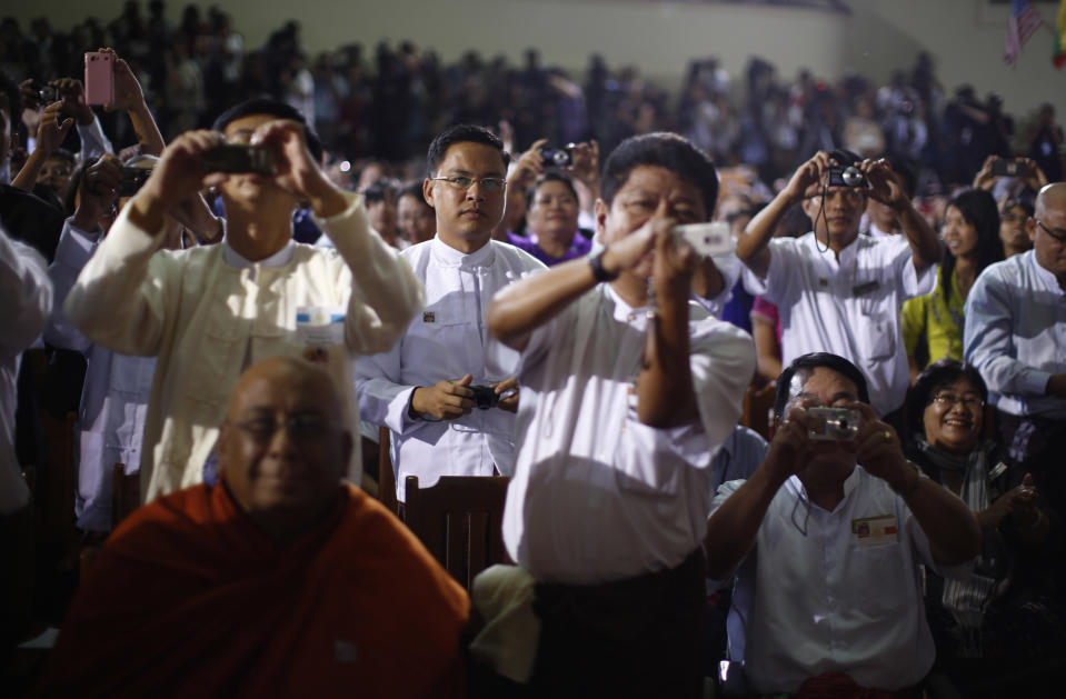 Members of the audience take pictures as U.S. President Obama delivers remarks at University of Yangon