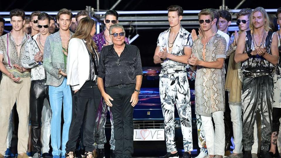 Roberto Cavalli greets the audience at the end of his show for the Menswear Spring-Summer 2015 in Milan