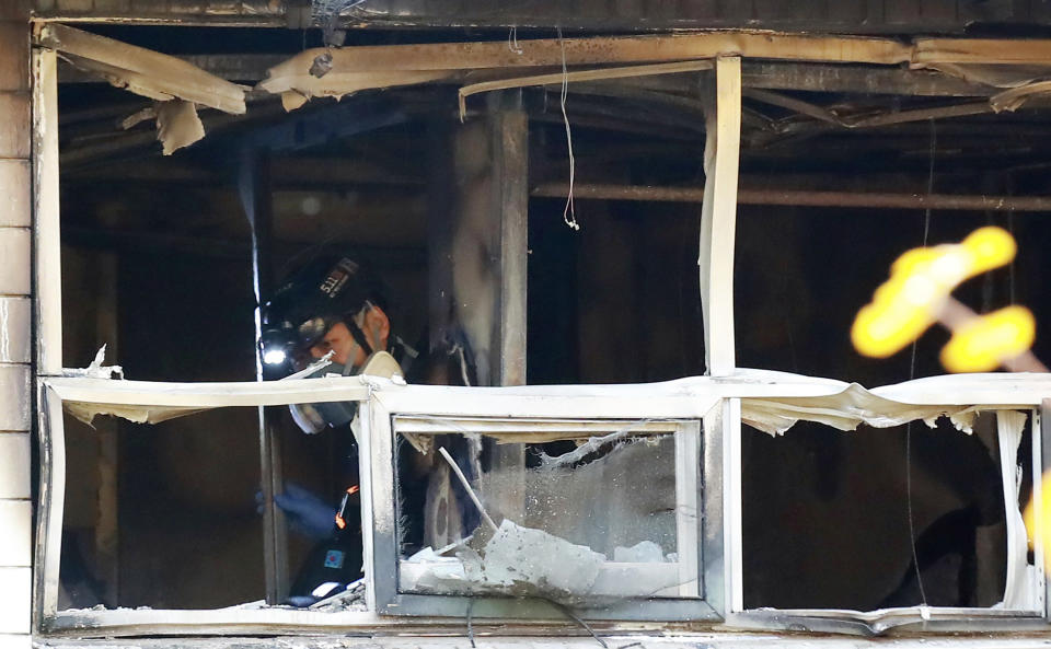 A South Korean officer inspects a fire site in Seoul, South Korea, Friday, Nov. 9, 2018. A fire at a low-cost dormitory-style housing facility in central Seoul killed several people on Friday, fire authorities said. (Hong Hae-in/Yonhap via AP)