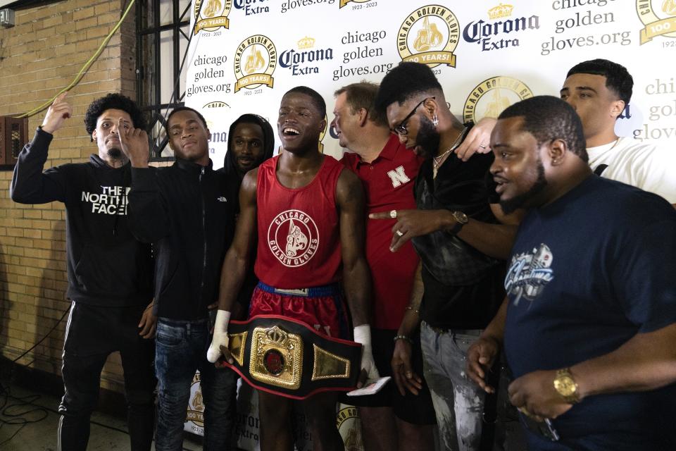 Theon Davis, 21, center, celebrates with friends after defeating Eduardo Camacho in the 176-pound championship bout on the final night of the 100th year of the Chicago Golden Gloves boxing tournament Sunday, April 16, 2023, in Cicero, Ill. Davis won by split decision. (AP Photo/Erin Hooley)