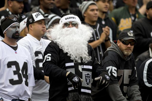 Oakland Raiders fans dressed in costumes arrive at the Oakland