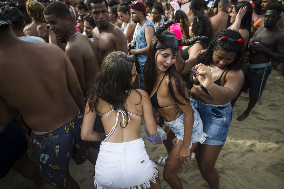 Women dance during the "Bloco da Favorita" street party on Copacabana beach, Rio de Janeiro, Brazil, Sunday, Jan. 12, 2020. Copacabana beach hosted the kick-off to the 50-day Countdown to Carnival with a concert and the "election" of King Momo to preside over festivities. (AP Photo/Bruna Prado)