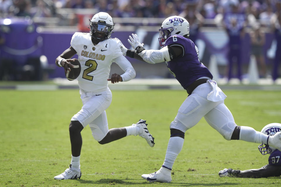 Colorado quarterback Shedeur Sanders (2) runs from TCU linebacker Jamoi Hodge (6) during the first half of an NCAA college football game Saturday, Sept. 2, 2023, in Fort Worth, Texas. (AP Photo/LM Otero)