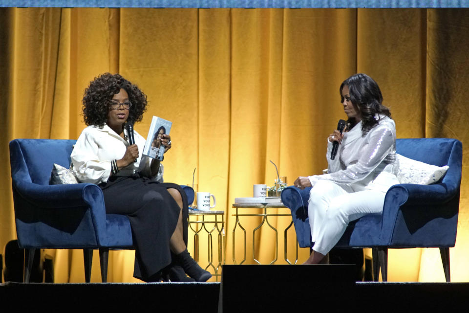 Michelle Obama, right, discusses her new book with Oprah Winfrey, left, during an intimate conversation to promote “Becoming” at the United Center on Tuesday, Nov. 13, 2018, in Chicago. (Photo by Rob Grabowski/Invision/AP)