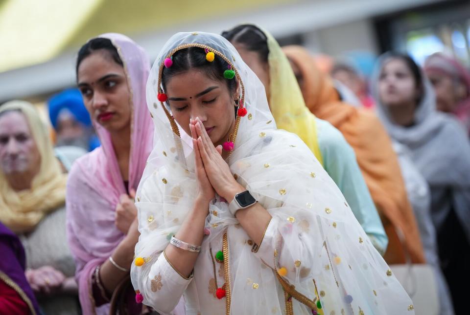 A woman pauses at the Khalsa Diwan Society Sikh temple before the Vaisakhi parade, in Vancouver, on Saturday, April 13, 2024. Vaisakhi is a significant holiday on the Sikh calendar, commemorating the establishment of the Khalsa in 1699 and marking the beginning of the Punjabi harvest year.