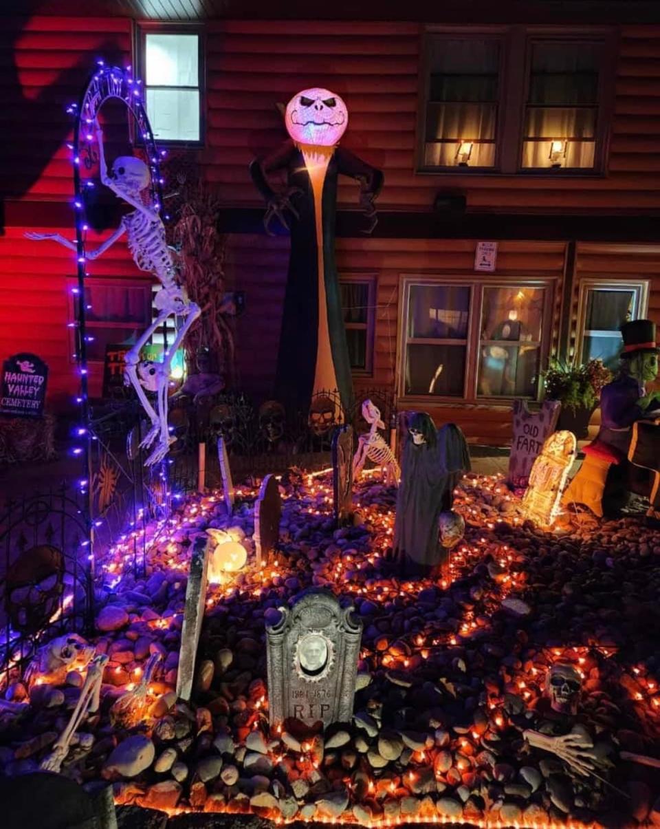 Purple and orange Halloween lights, gravestones and skeletons welcome passerby in the front lawn of 1970 S. Kings Ave. in Springfield.