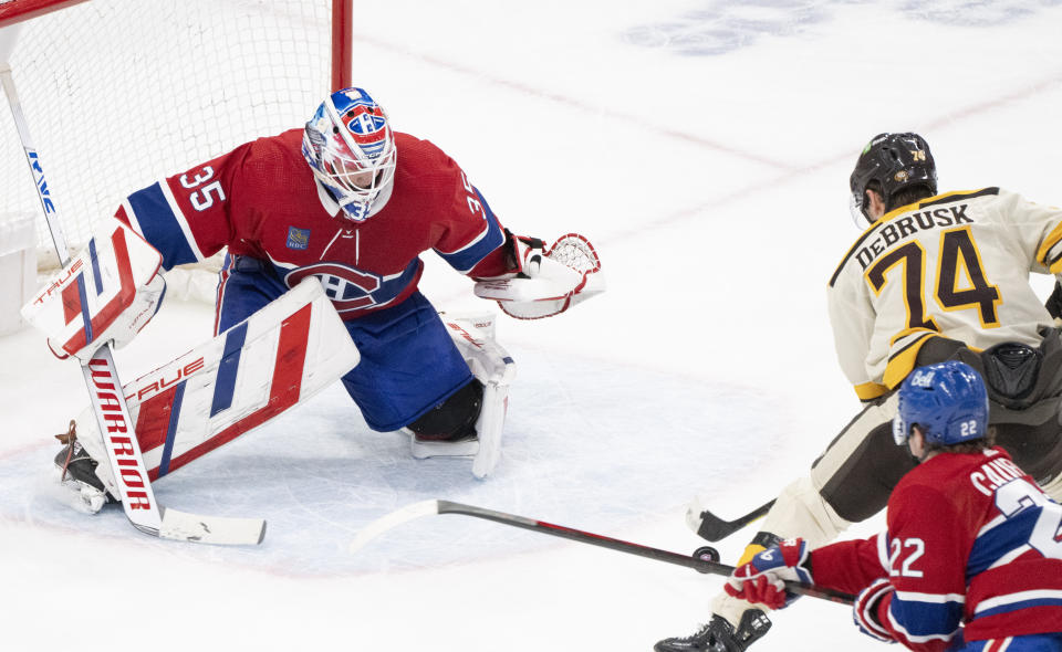 Boston Bruins' Jake DeBrusk (74) drives in to score against Montreal Canadiens goaltender Sam Montembeault (35) during overtime NHL hockey action in Montreal, Thursday, March 14, 2024. (Christinne Muschi/The Canadian Press via AP)