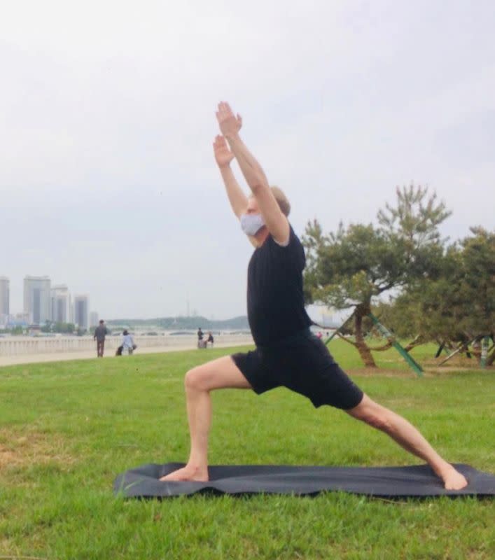 Swedish Ambassador Joachim Bergstrom practices yoga in a park in Pyongyang