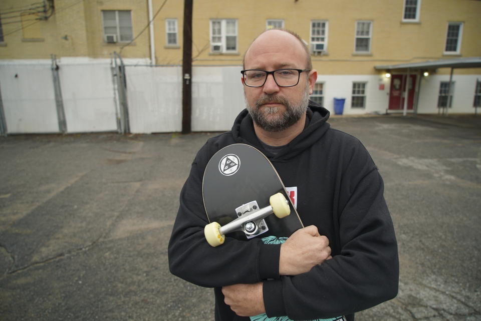 Hunter Demster, an activist, hugs a skateboard outside his office in Memphis, Tenn., on Monday, Jan. 30, 2023. Demster, who works with the group Decarcerate Memphis, says he often gets calls for help from Black motorists, like late skateboarded Tyre Nichols, who have been stopped by police for what he considers "nefarious" reasons. (AP Photo/Allen G. Breed)