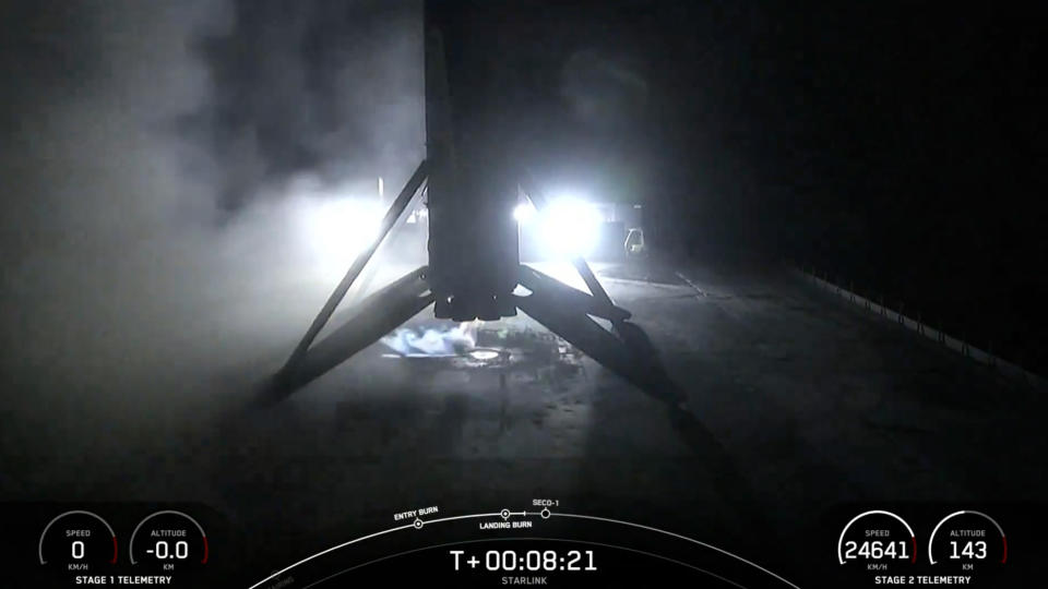 A black and white spacex falcon 9 rocket first stage sits on the deck of a ship at sea.