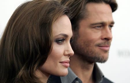 Angelina Jolie and Brad Pitt arrive at the screening of her directorial debut "In the Land of Blood and Honey" in New York December 5, 2011. REUTERS/Carlo Allegri/Files