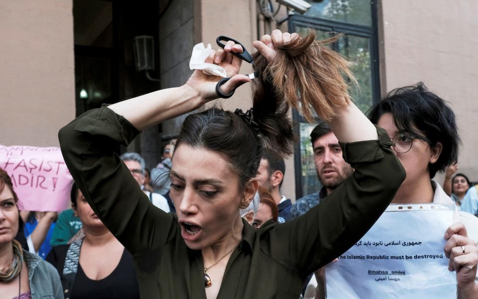 Nasibe Samsaei, an Iranian woman living in Turkey, cuts her hair during a protest following the death of Mahsa Amini - MURAD SEZER