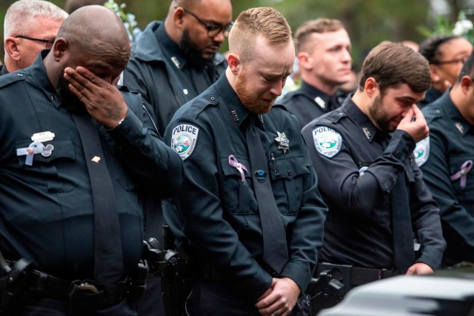 Bay St. Louis police officers react as Capt. Rachel Jewell calls in the last radio call at the gravesite of Bay St. Louis police officers Sgt. Steven Robin and Branden Estorffe at Gardens of Memory cemetery in Bay St. Louis on Wednesday, Dec. 21, 2022. Robin and Estorffe were killed responding to a call at a Motel 6 on Dec. 14.