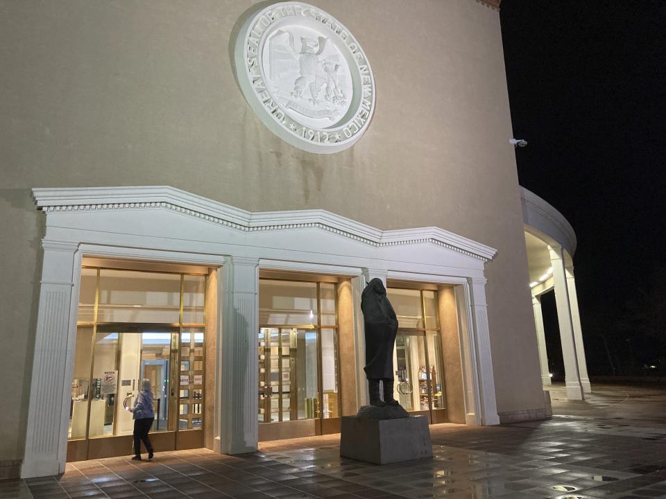 A visitor enters the New Mexico state Capitol building in Santa Fe, N.M., on Thursday, March 16, 2023, as legislators debated late into the evening. (AP Photo/Morgan Lee)