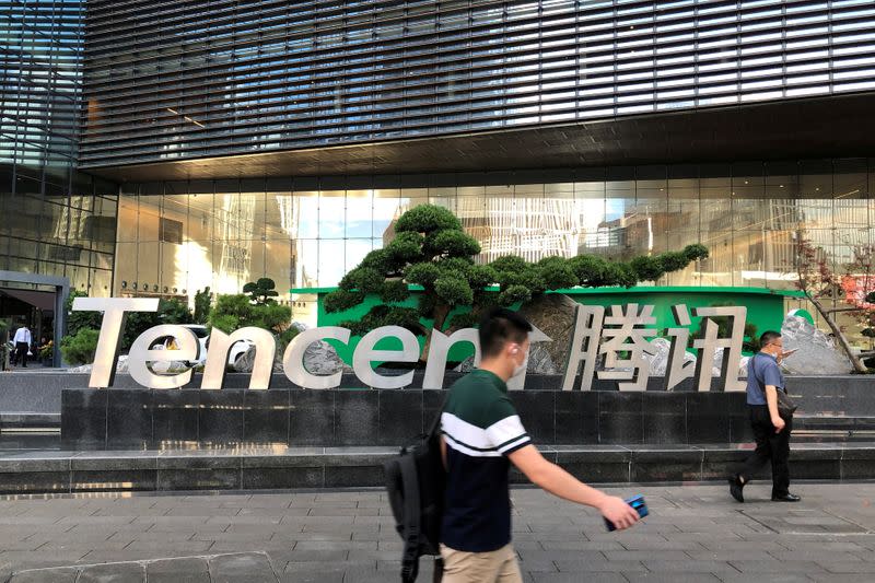 FILE PHOTO: People walk past a Tencent sign at the company headquarters in Shenzhen