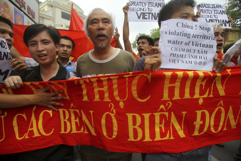FILE - In this June 12, 2011 file photo, Vietnamese protesters carry a banner with a Vietnamese slogan reading, "China must respect and execute the Declaration on the Conduct of Parties in the South China Sea," during a protest demanding China to stay out of their waters following China's increased activities around the Spratly Islands and other disputed areas, in Hanoi, Vietnam. Vietnam demanded China stop oil drilling operations in a disputed patch of the South China Sea, saying on Monday, May 5, 2014 that Beijing's decision to deploy a deep sea rig over the weekend was illegal. China dismissed the objections, saying the activity was being carried out in its territorial waters. (AP Photo/Na Son Nguyen, File)