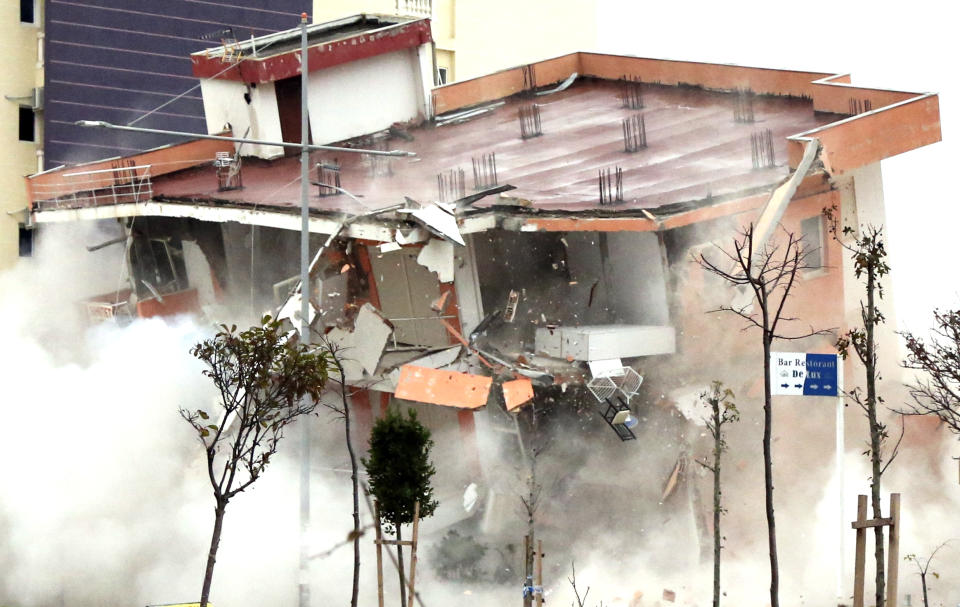 The Albanian army uses a remote-controlled explosion to demolish a building in the western port city of Durres, Albania, Tuesday, Dec. 3, 2019. A remote-controlled explosion has demolished the six-storied building considered threatening after being damaged from the 6.4 magnitude earthquake in Albania. A quake a week ago killed 51 persons, injured more than 3,000 people, and damaged more than 11,000 buildings. (AP Photo/Hektor Pustina)