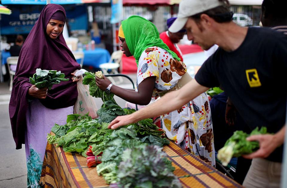 A Somali immigrant shops at a farmers market in San Diego’s City Heights neighborhood. <a href="https://www.gettyimages.com/detail/news-photo/shopper-from-somalia-l-peruses-vegetables-on-sale-at-the-news-photo/595283814?adppopup=true" rel="nofollow noopener" target="_blank" data-ylk="slk:Sandy Huffaker/Corbis via Getty Images;elm:context_link;itc:0;sec:content-canvas" class="link ">Sandy Huffaker/Corbis via Getty Images</a>