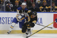 Boston Bruins right wing David Pastrnak (88) and Buffalo Sabres defenseman Jacob Bryson (78) collide while going after the puck during the second period of an NHL hockey game Friday, Oct. 22, 2021, in Buffalo, N.Y. (AP Photo/Joshua Bessex)