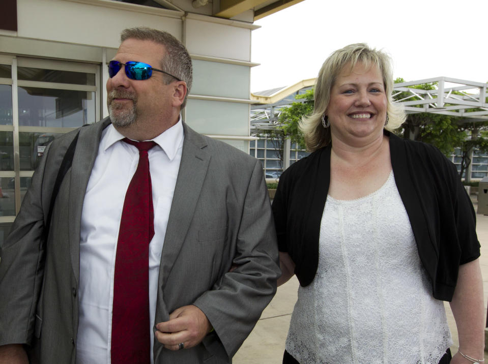 FILE - In this May 26, 2018, file photo, Laurie Holt, right, and Jason Holt arrive at Ronald Reagan Washington National Airport in Arlington, Va., to meet their son, Joshua Holt. Laurie Holt, a Utah woman who spent nearly two years pushing to get her son freed from a Venezuelan jail, has died at age 50. (AP Photo/Jose Luis Magana, File)