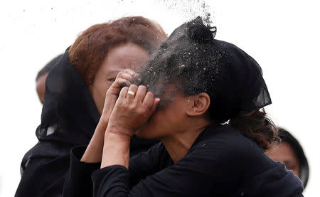 A relative puts soil on her face as she mourns at the scene of the Ethiopian Airlines Flight ET 302 plane crash, near the town Bishoftu, near Addis Ababa, Ethiopia March 14, 2019. REUTERS/Tiksa Negeri/Files